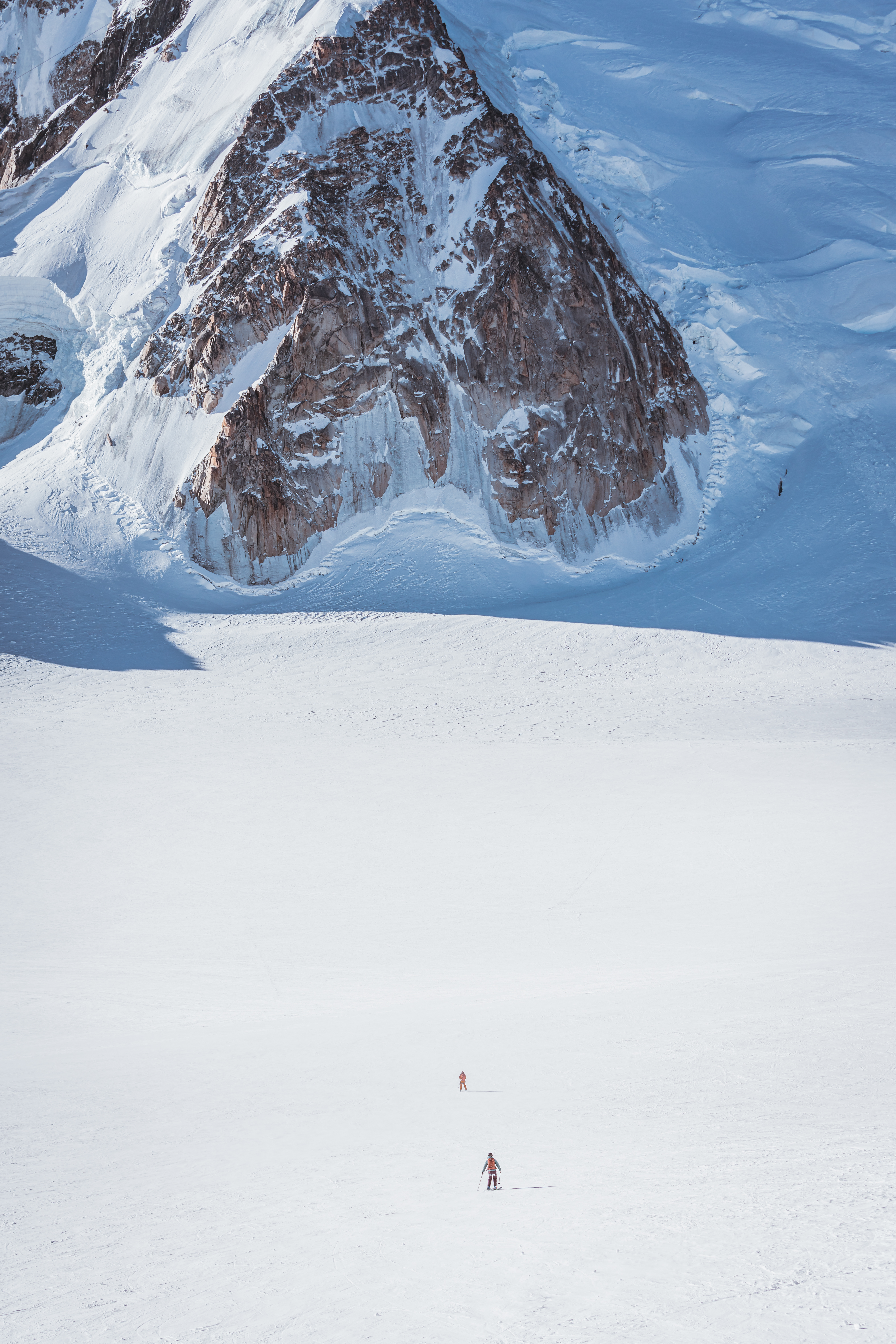This is a photo of Glacier, Ice, Mountain, Nature, Outdoors, Slope, Person, Mountain Range, Peak, Clothing, Footwear, Shoe, Piste, Snow, Sport, Scenery